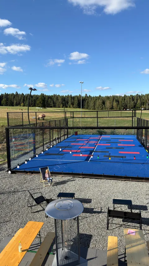 Padel-Court mit vorbereiteten Trainingsmatten und Sitzplätzen im Sonnenschein