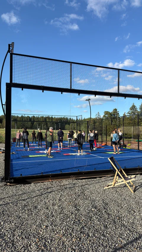 Teilnehmende beim gemeinsamen Training auf dem blauen Padel-Court